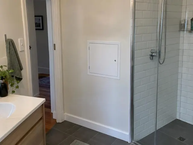 Neat white access panel on a bathroom wall beside a tiled shower in Naremburn